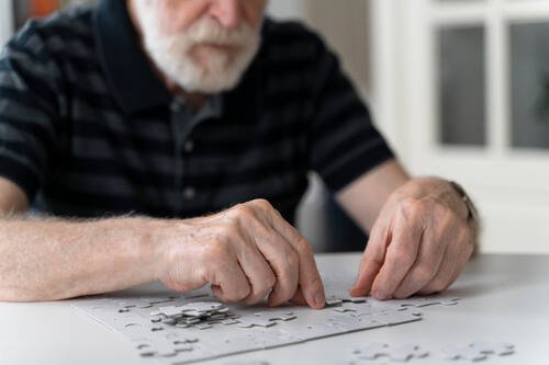 Uomo anziano tenta di completare un puzzle